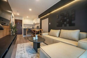 Ein modernes Wohnzimmer mit einer Couch, einem Couchtisch und einem Essbereich mit Stühlen und einem Tisch.