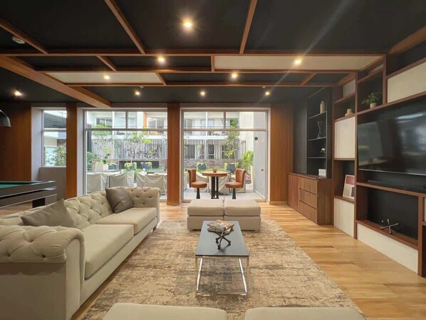 A modern living room with a sofa, coffee table, and TV stand.