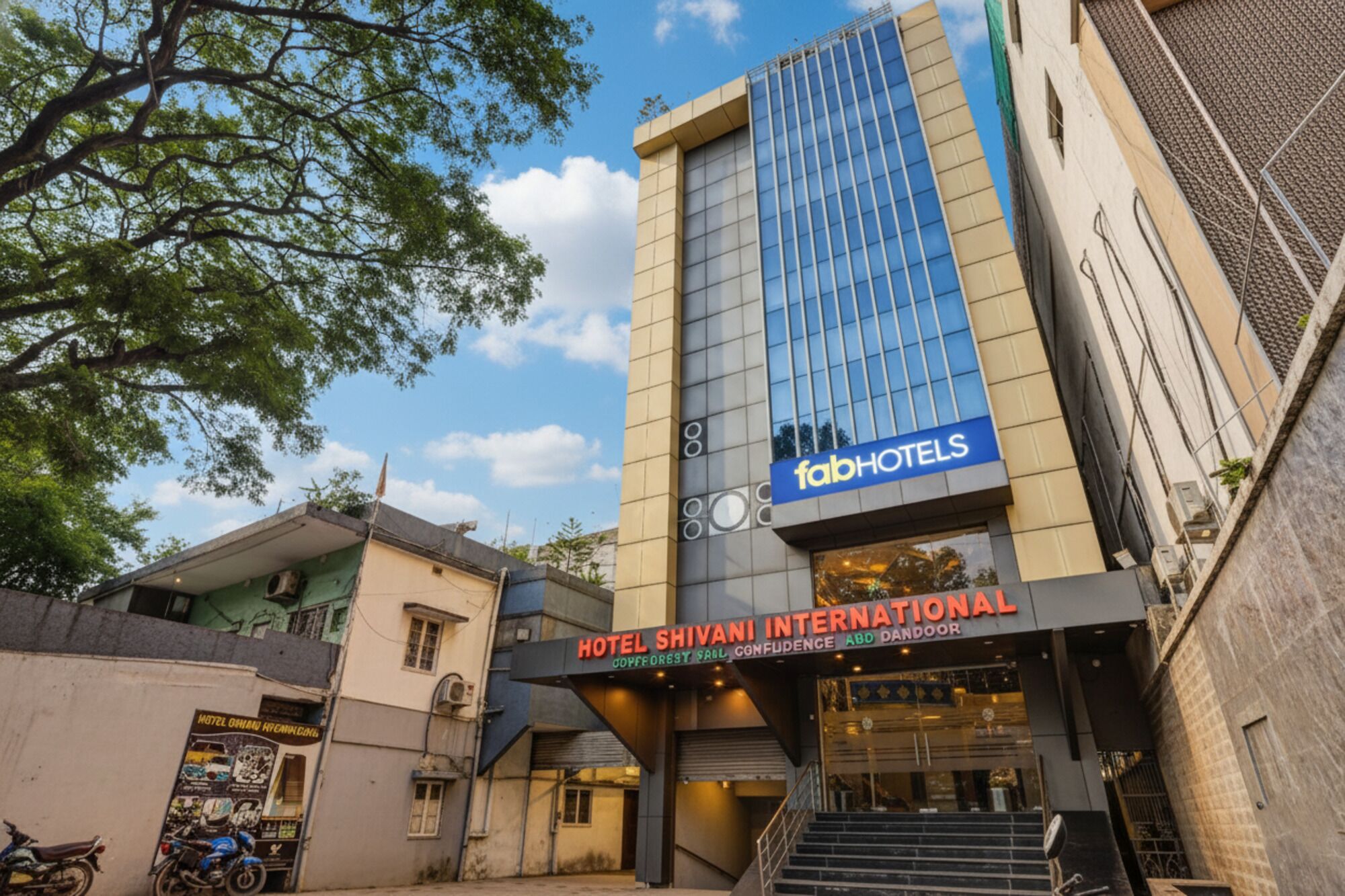 Hotel Shivani International with a modern facade, a prominent sign for FabHotels, and a staircase leading to the entrance.