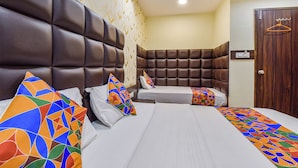 Een hotelkamer met een groot bed, twee kussens, een nachtkastje en een kledingkast.