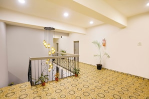 A staircase with a patterned floor, a metal railing, and hanging lights. - Fabhotel Vibes (Vagator)