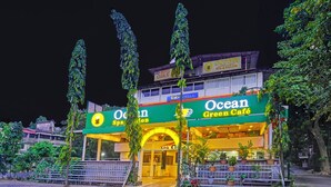 A building with a green sign reading "Ocean Green Café" and "Spa".