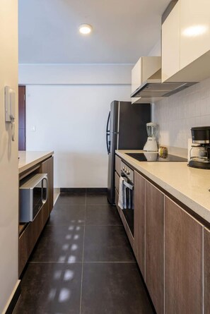 Eine moderne Küche mit Einbauofen, Kühlschrank und Kaffeemaschine.