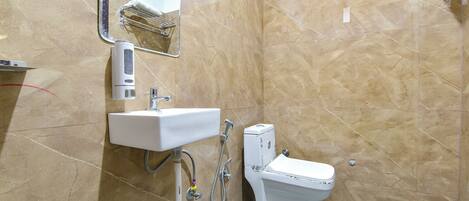 A bathroom with a white sink, a toilet, and a mirror.