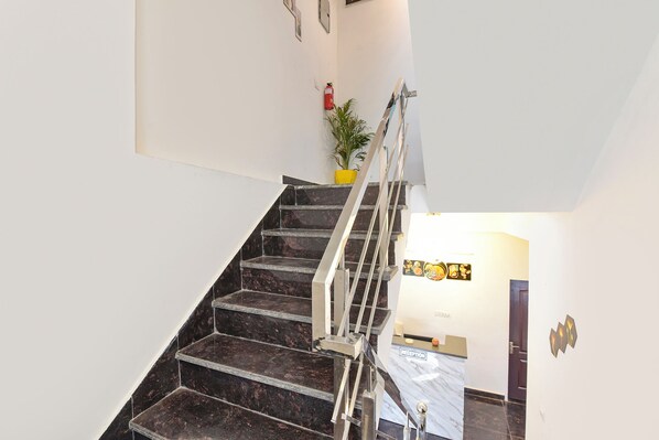 A staircase with a metal handrail leading to a reception area.