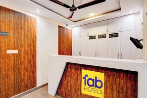 Un hall d’hôtel avec un mur d’accent en bois, un ventilateur de plafond et un panneau indiquant « hôtels de qualité ».