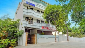 Un immeuble à plusieurs étages, sur lequel on peut lire les enseignes « Tab Hotels » et « Angel Pink Residence ».