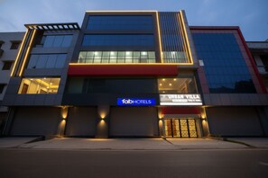 Un hôtel moderne, reconnaissable à son grand panneau « TabHotels », à ses larges fenêtres et à son panneau « Urban Villa ».