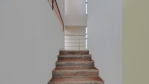 A staircase with a metal railing leading to a landing. - Fabhotel Rio (Hyderabad)