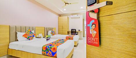A hotel room with a bed, bedside table, and a wall-mounted digital door lock.