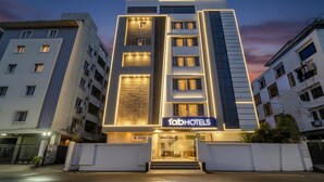 Un hôtel moderne, reconnaissable à son enseigne « fabHOTELS » bien visible, avec de nombreux étages et une entrée bien éclairée.