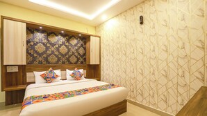 A bedroom with a bed, wooden headboard, and patterned wallpaper. - FabHotel Joy Residency (Chennai)