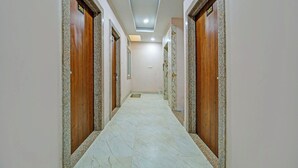 A hallway with marble flooring and wooden doors, numbered 301 and 302, leading to rooms.