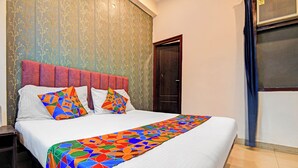 Ein Hotelzimmer mit Bett, Kopfteil, Tür und Fenster.