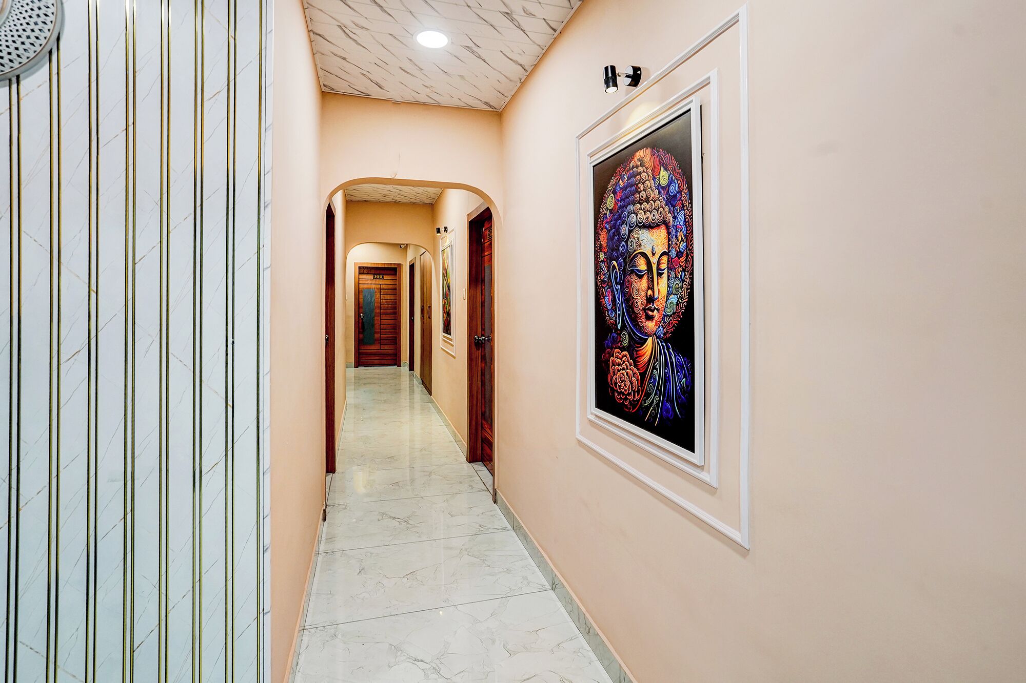 Un pasillo con piso de mármol, una obra enmarcada en la pared y una puerta con la leyenda 'ROOM 301'.