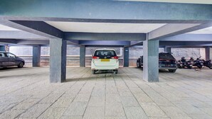 Un parking avec des piliers en béton et un sol carrelé.