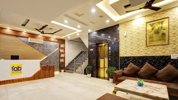 A hotel reception area with a reception desk, a staircase, a sofa, and a coffee table. - FabHotel Church View - 500m from New Delhi Railway Station (New Delhi)