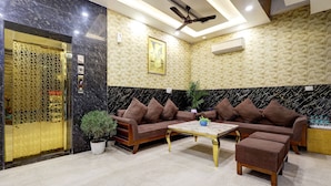 A modern lobby with a marble reception desk, a sofa set, a coffee table, and a ceiling fan. - FabHotel Church View - 500m from New Delhi Railway Station (New Delhi)