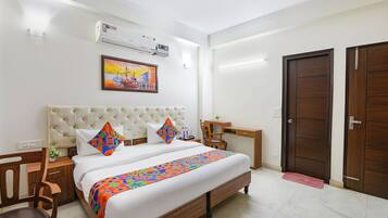 Una camera d'albergo con un letto, una scrivania e un armadio.