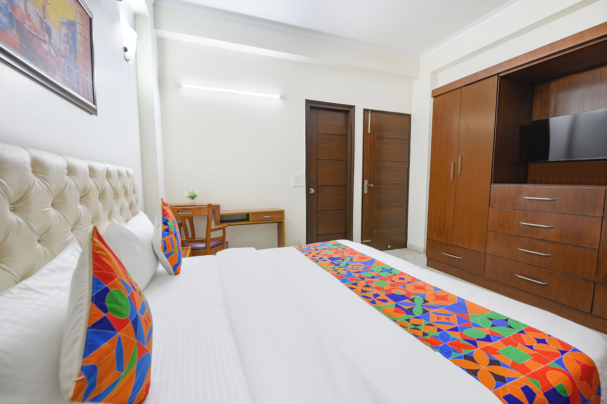 Un dormitorio con cama, escritorio y armario.