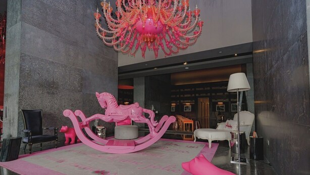 A lobby with a pink rocking horse, a chandelier, and a white sofa. - Exclusive and luxury 1BR with balcony in Yoo Panama (Panamá)