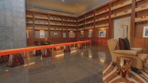A library with bookshelves, a long wooden bench, and a sofa. - Exclusive and luxury 1BR with balcony in Yoo Panama (Panamá)