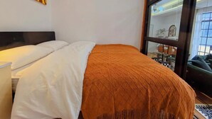 A hotel room with a bed, a nightstand, a window with a view, and wall art. - Shanghai Hills & Zinn Sunshine bnb (Shanghai)