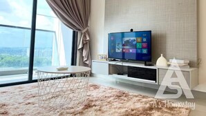 Un salon moderne doté d’une grande fenêtre, d’un téléviseur à écran plat, d’une table basse ronde et d’un tapis moelleux.