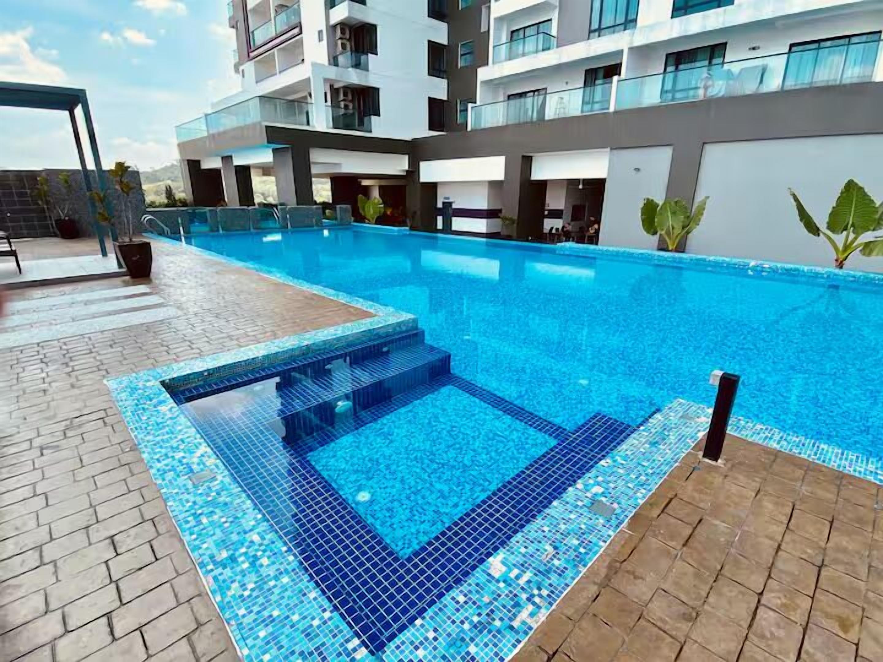 A modern hotel with a swimming pool featuring a mosaic tile design.