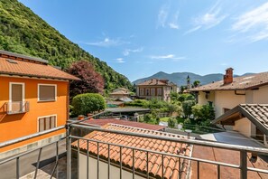 Zona residencial con tejados de tejas de color terracota, montañas al fondo y cielo despejado.