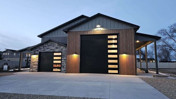 A modern building with two large garage doors and a covered entrance area.