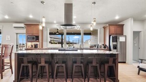 A spacious kitchen with a large island, bar stools, and modern appliances.