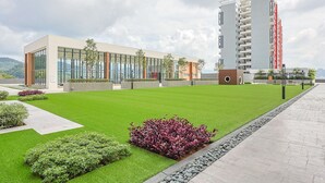 A modern building with large windows, a well-maintained lawn, and a pathway.