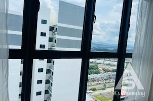 A view from a window with a view of a modern building and a parking lot.