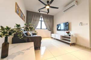 Una sala de estar moderna con un sofá, una mesa de centro, un televisor y un ventilador de techo.
