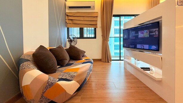 Ein modernes Wohnzimmer mit einer Couch, einem Flachbildfernseher und einem Deckenventilator.