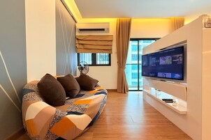 Uma sala de estar moderna com sofá, televisão de tela plana e ventilador de teto.