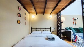 A bedroom with a bed, bedside lamps, a wall with decorative plates, and a view of the outside. - Shanghai Hills & Zinn Happy Family Bnb (Shanghai)