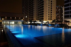 A nighttime swimming pool with water features and a building in the background. - Amerin Residence Mall Apartments (Seri Kembangan)