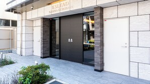 A modern building entrance with a sign reading "ESLEAD NAMBAMBU KUROMON".
