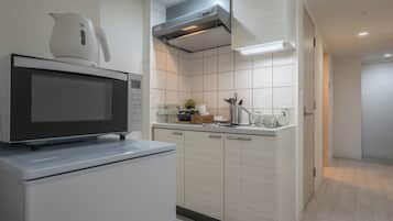 A modern kitchen with a built-in microwave, a stainless steel range hood, and a tiled backsplash.