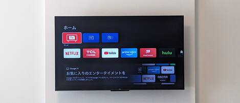 A flat-screen TV mounted on a wall displaying various streaming service icons.