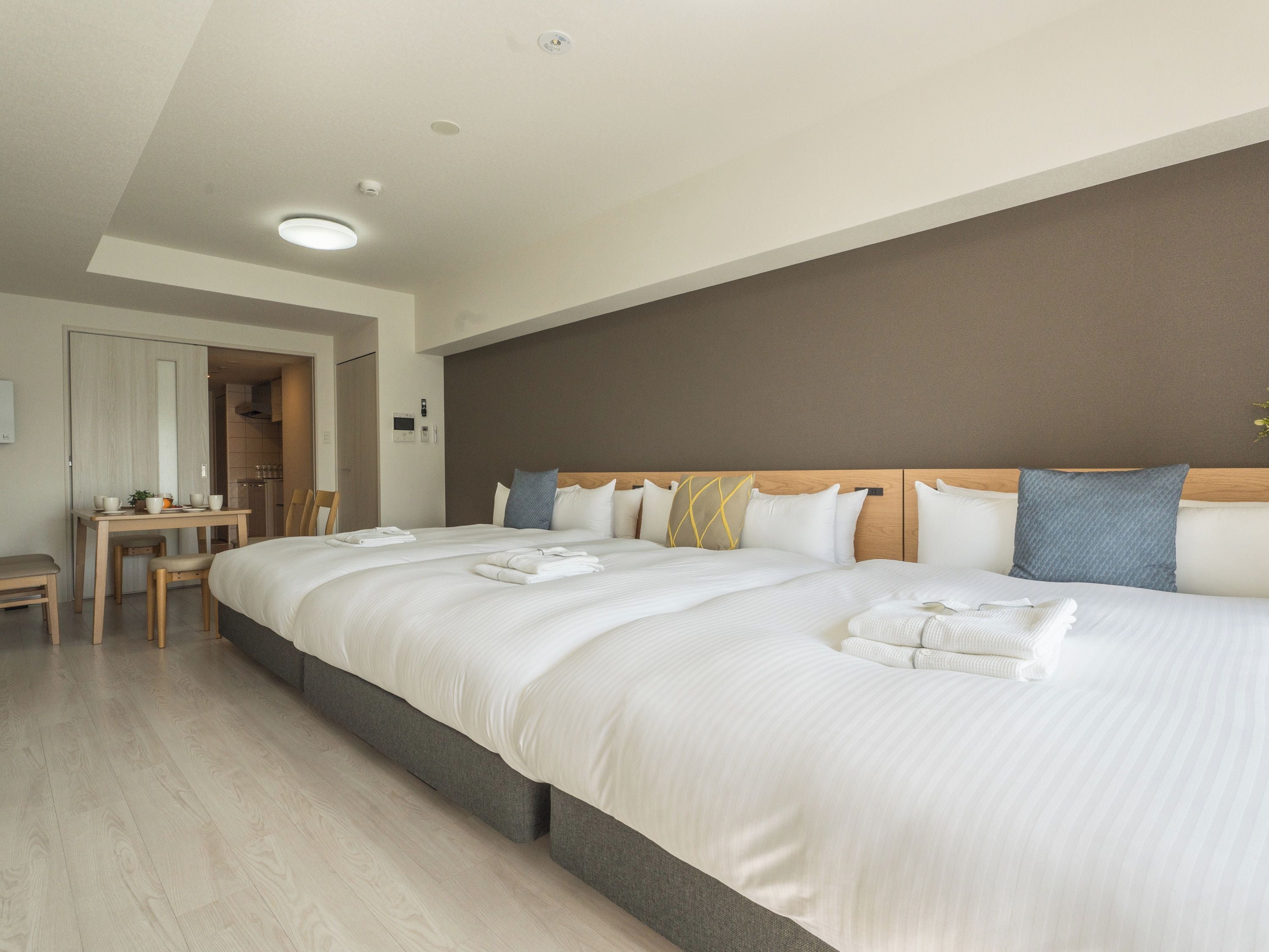 A hotel room with a large bed, a desk, and a chair.
