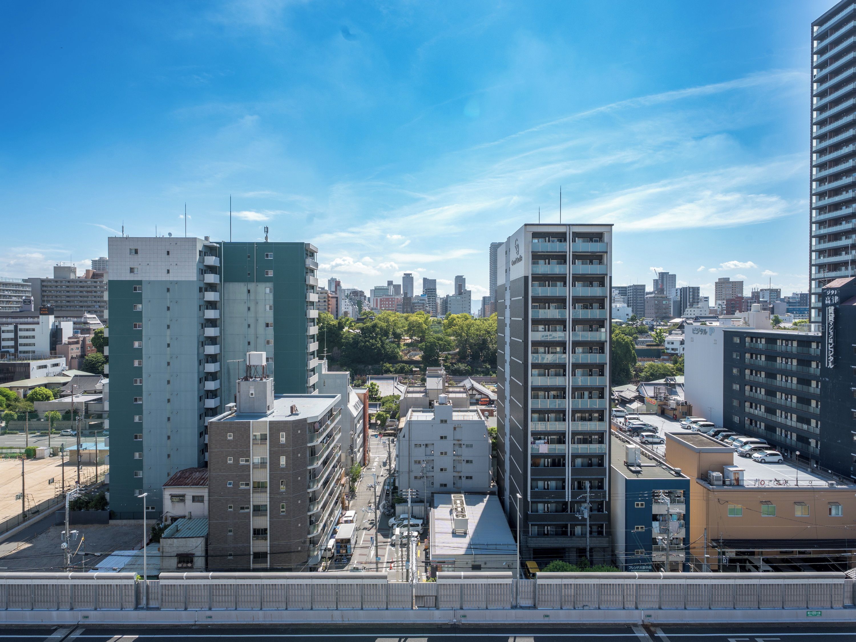 A high-rise building with multiple floors, surrounded by other buildings and a clear sky.