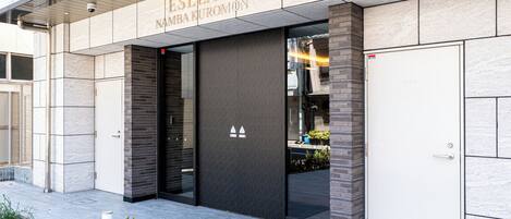 A modern building entrance with a sign reading 'ESLEAD NAMBAKUROMON'.