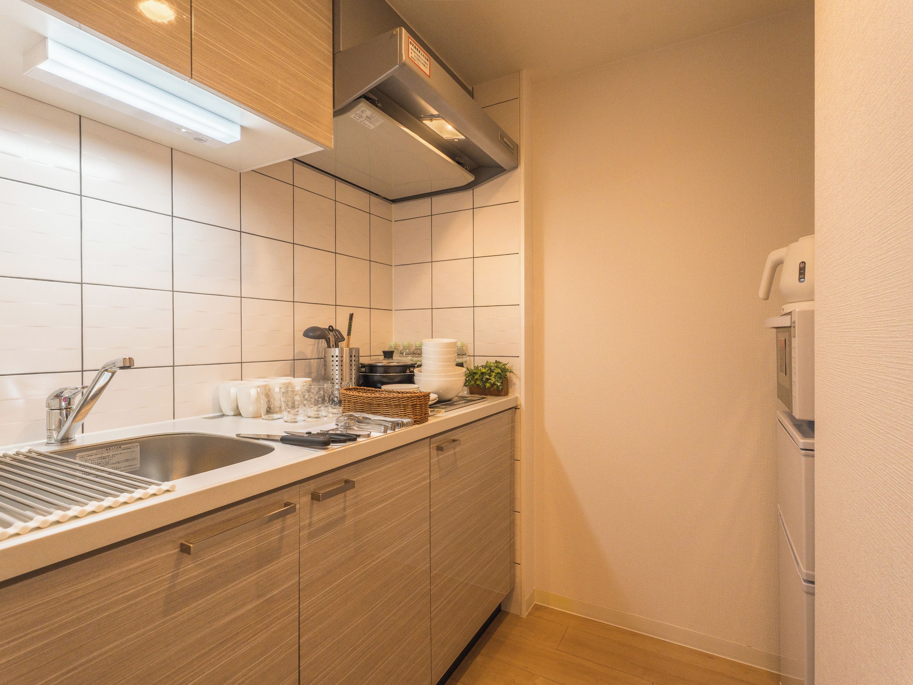 A modern kitchen with a stainless steel sink, wooden cabinets, and a built-in oven.