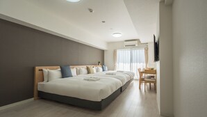 A modern hotel room with a large bed, a desk, and a television.
