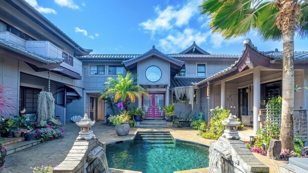 Une cour intérieure avec une piscine centrale, entourée d’une architecture traditionnelle et d’une végétation luxuriante.