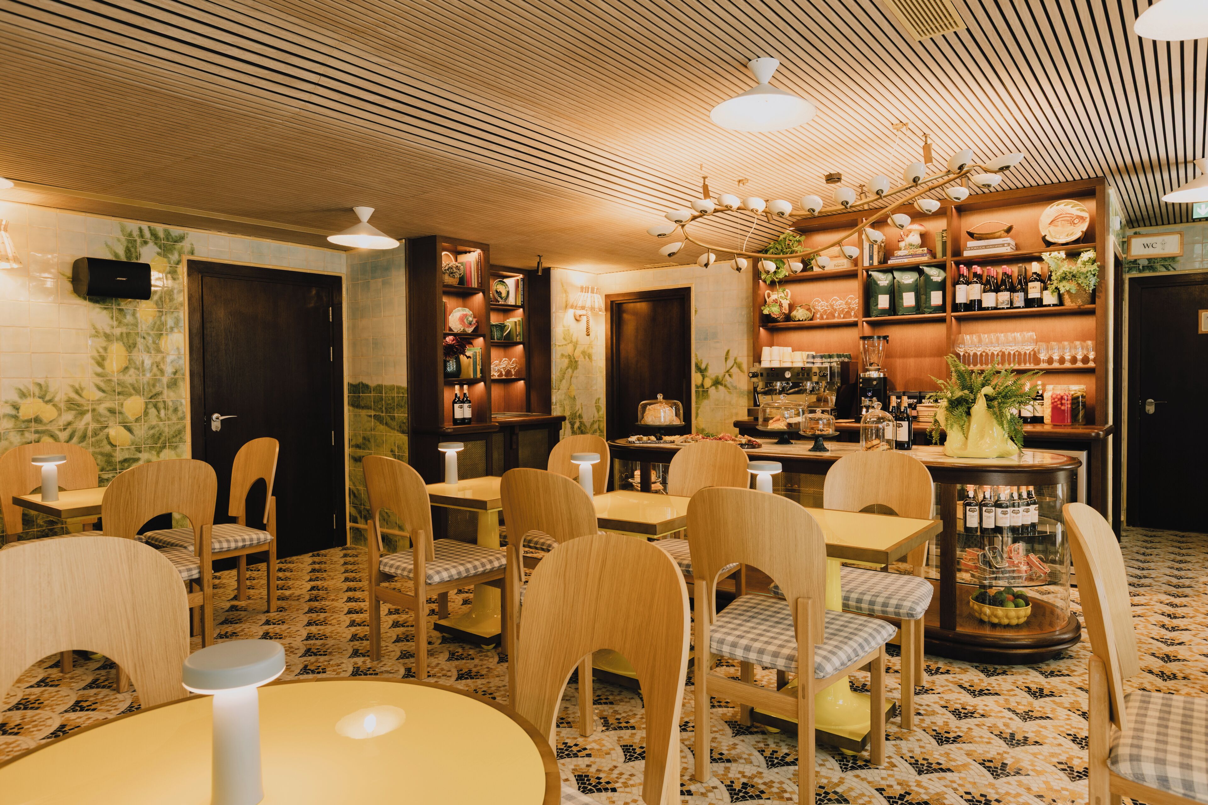 Een restaurant met houten meubels, een vloer met patroon en diverse objecten op planken.