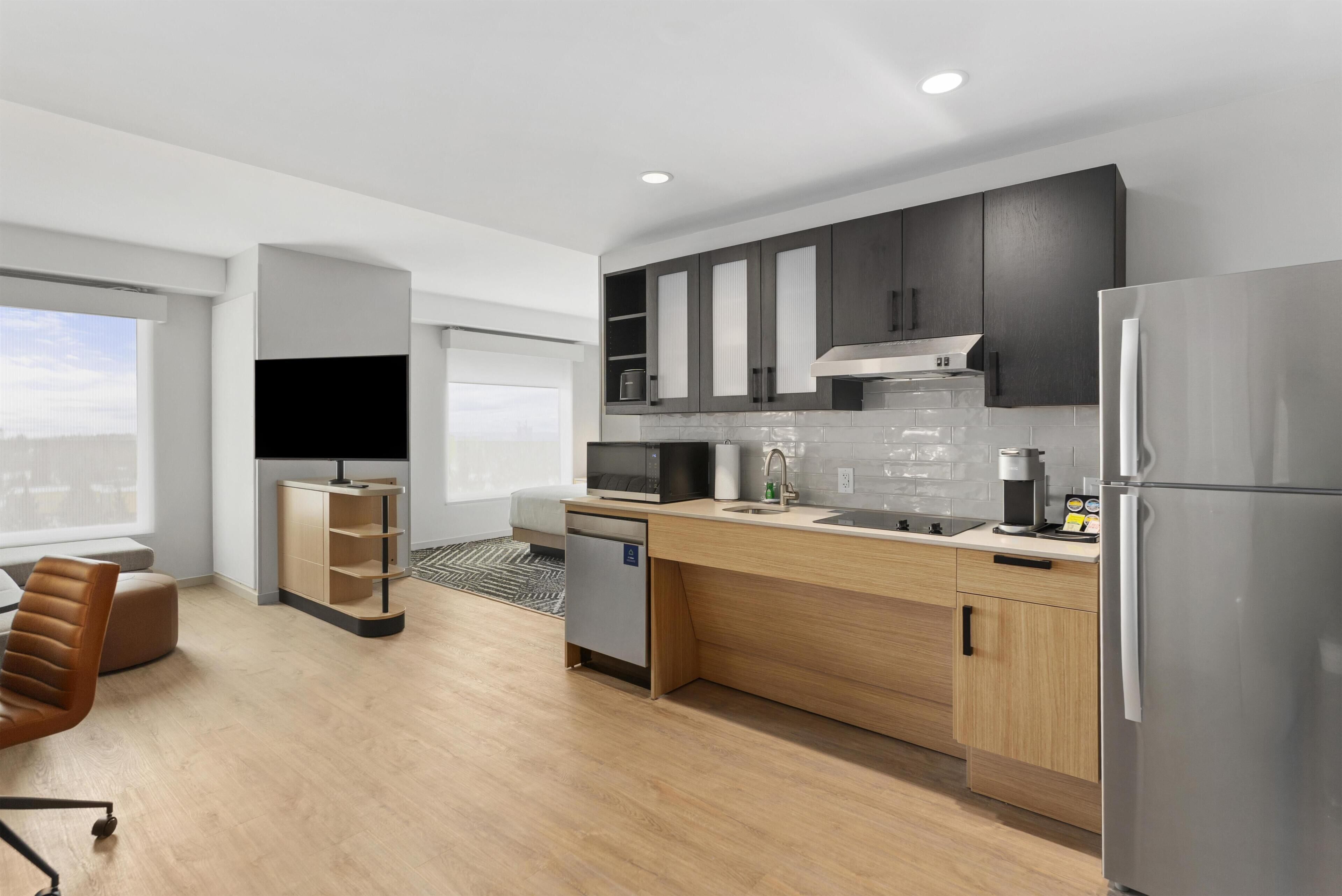 A modern kitchen with a built-in dishwasher, a coffee machine, and a refrigerator.
